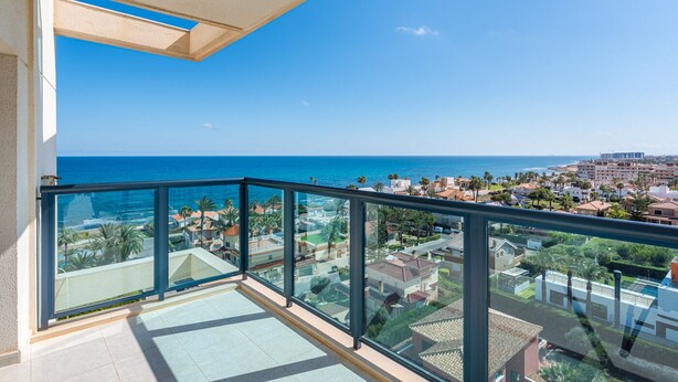 Ein Balkon mit freiem Blick auf das Meer und eine Küstenstadt.