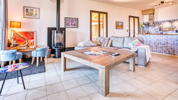 Una sala moderna con un sofá, una mesa de centro de madera y una chimenea.