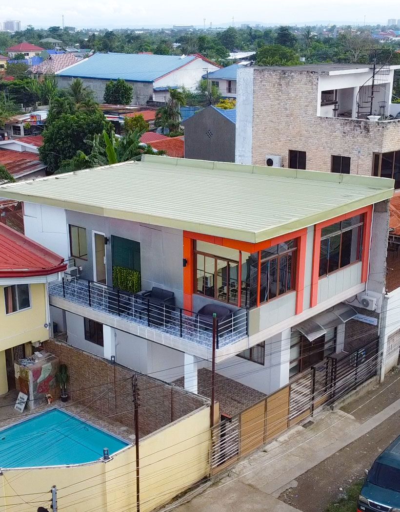 Un immeuble de deux étages doté d’une piscine, d’un balcon et offrant une vue sur le quartier environnant.
