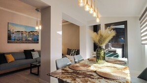 Una sala de estar moderna con un sofá, una mesa de comedor con individuales y un cuadro en la pared.