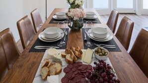 Ein Esszimmer mit einem Holztisch, gedeckt für sechs Personen, umgeben von Ledersesseln.