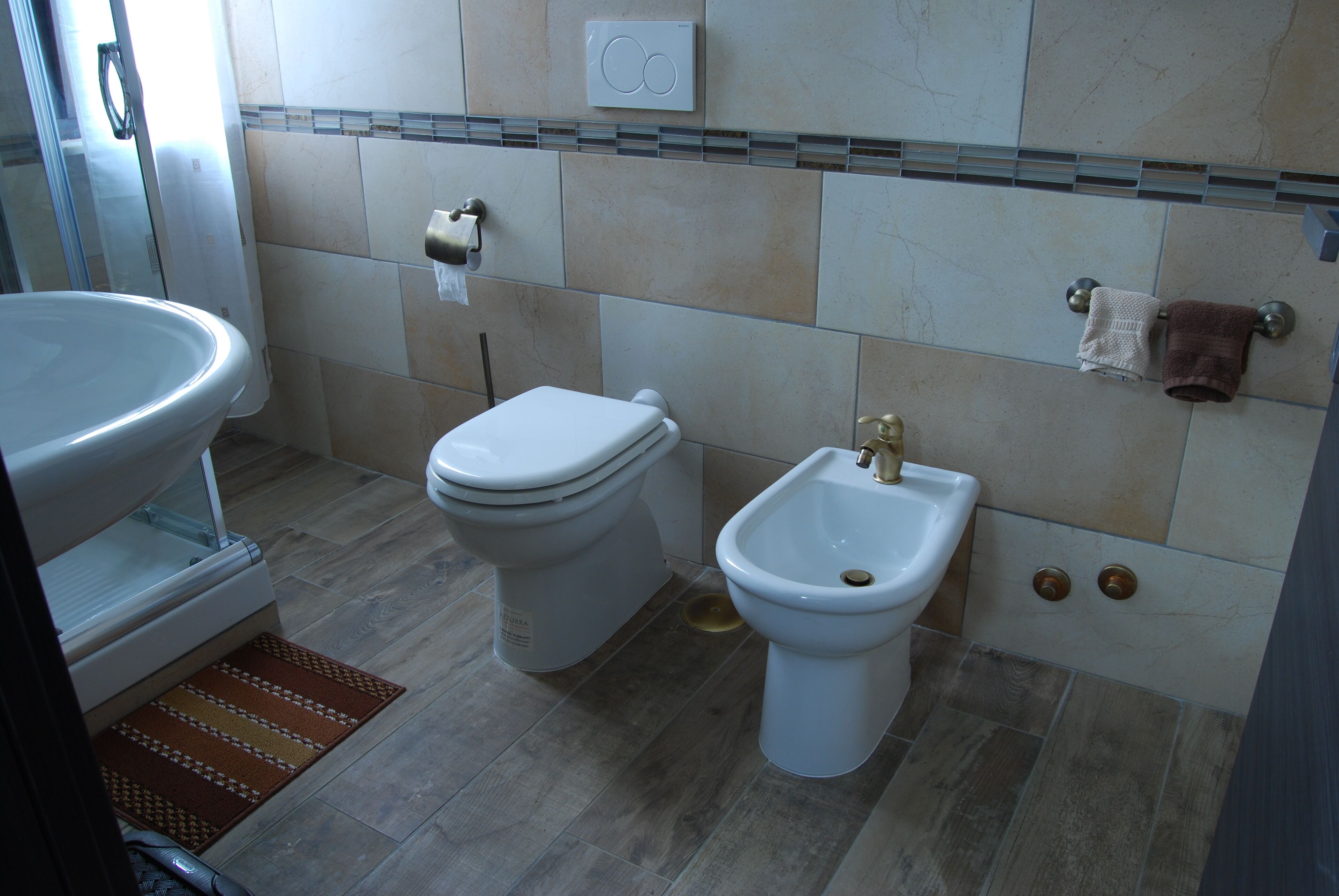 A bathroom with a toilet, bidet, and sink.