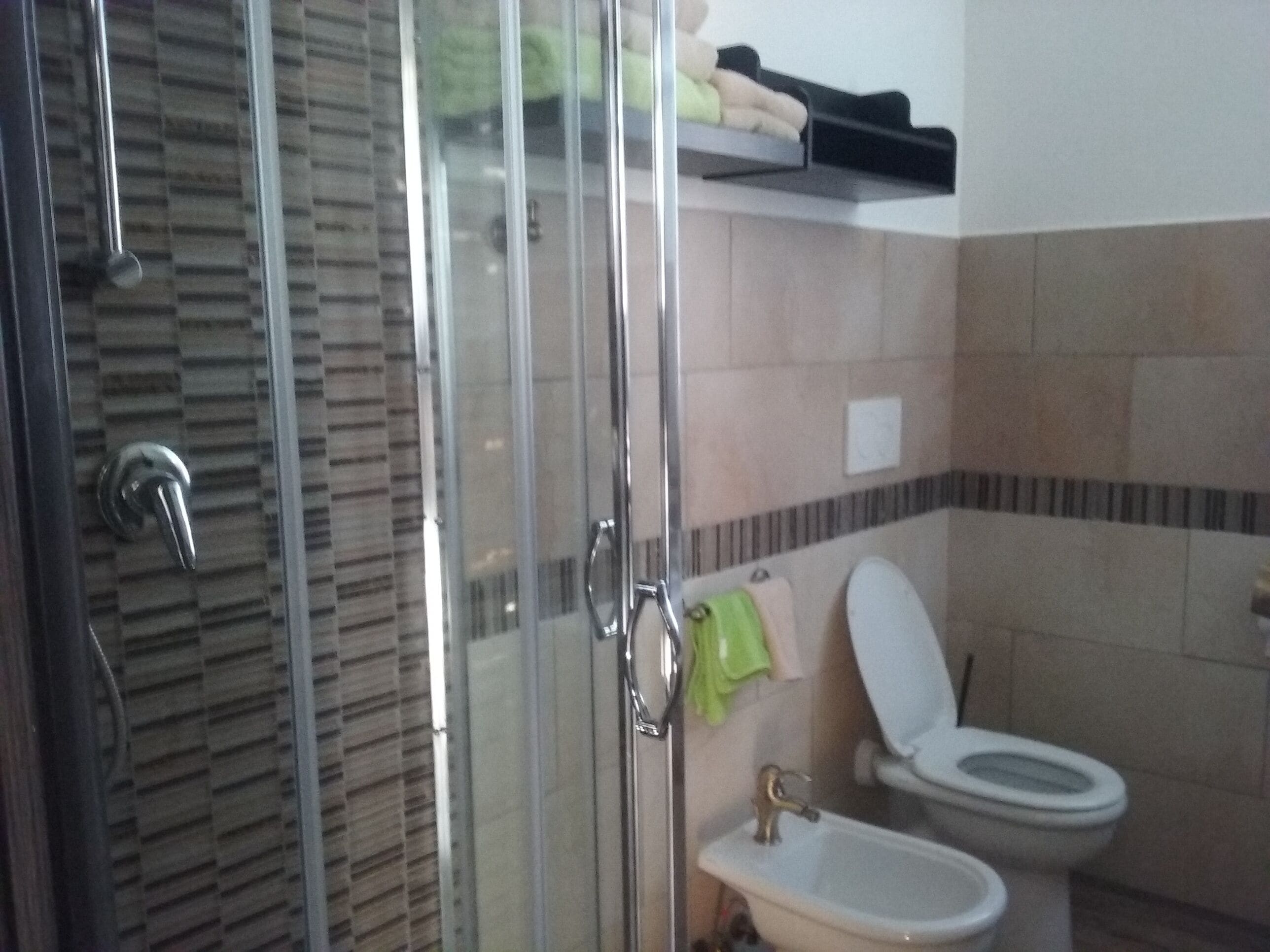 Un baño con cabina de ducha de vidrio, inodoro y lavabo.