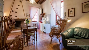 Una cocina acogedora con comedor, que incluye una mesa de madera, sillas y un sofá verde.