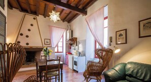 Una cocina acogedora con comedor, que incluye una mesa de madera, sillas y un sofá verde.