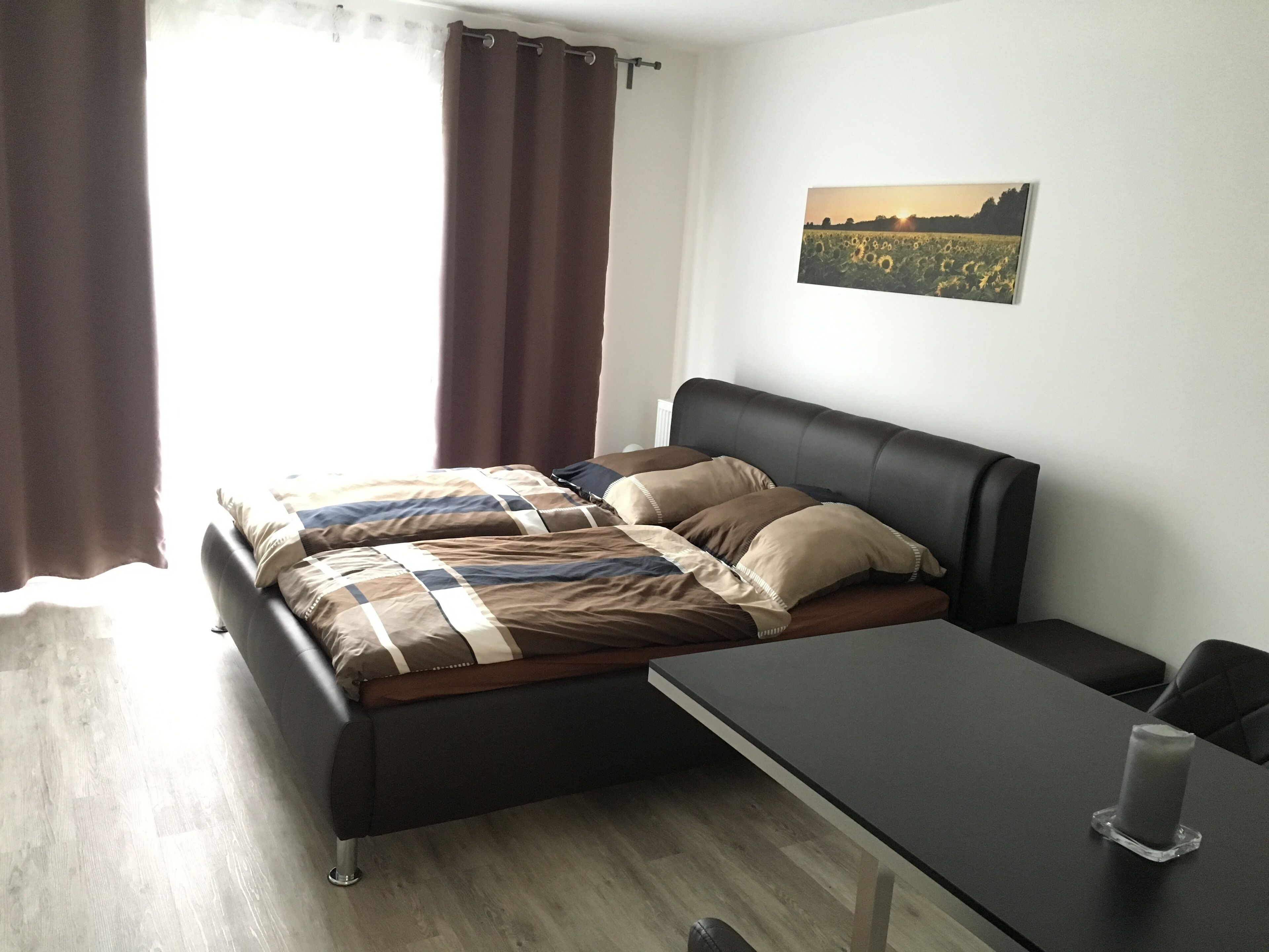 Ein modernes Schlafzimmer mit einem Bett, einem Nachttisch und einem Wandbild.