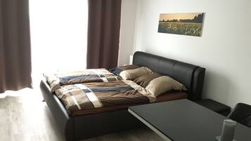 Ein modernes Schlafzimmer mit einem Bett, einem Nachttisch und einem Wandbild.