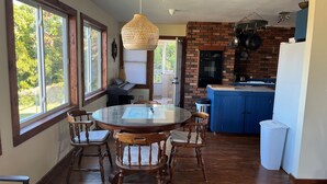 A kitchen with a brick wall, a blue countertop, and hanging pots.