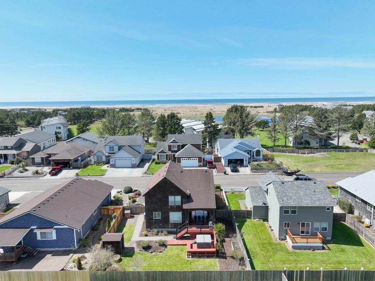 Un barrio residencial con casas, una carretera y una playa al fondo.