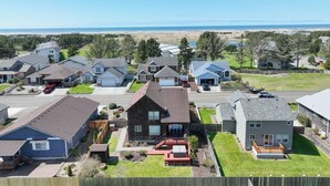 Un barrio residencial con casas, una carretera y una playa al fondo.