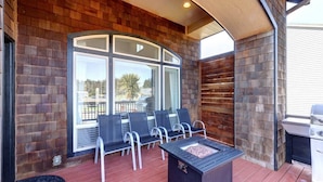 Un patio techado con una chimenea, asientos exteriores y una parrilla.