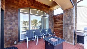 Un patio techado con una chimenea, asientos exteriores y una parrilla.