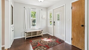 A hallway with a bench, a patterned rug, and a door. - Affordable & Spacious home near Minneapolis (Minneapolis)