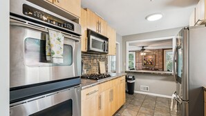 A modern kitchen with stainless steel appliances, wooden cabinets, and a tiled backsplash. - Affordable & Spacious home near Minneapolis (Minneapolis)
