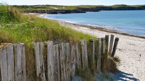 A sandy beach with a wooden fence and grassy vegetation. - A 2 pas de la plage, la Villa YIN (Saint-Pierre-Quiberon)