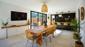 A modern kitchen with a wooden island, black chairs, and a hanging light fixture. - A 2 pas de la plage, la Villa YIN (Saint-Pierre-Quiberon)