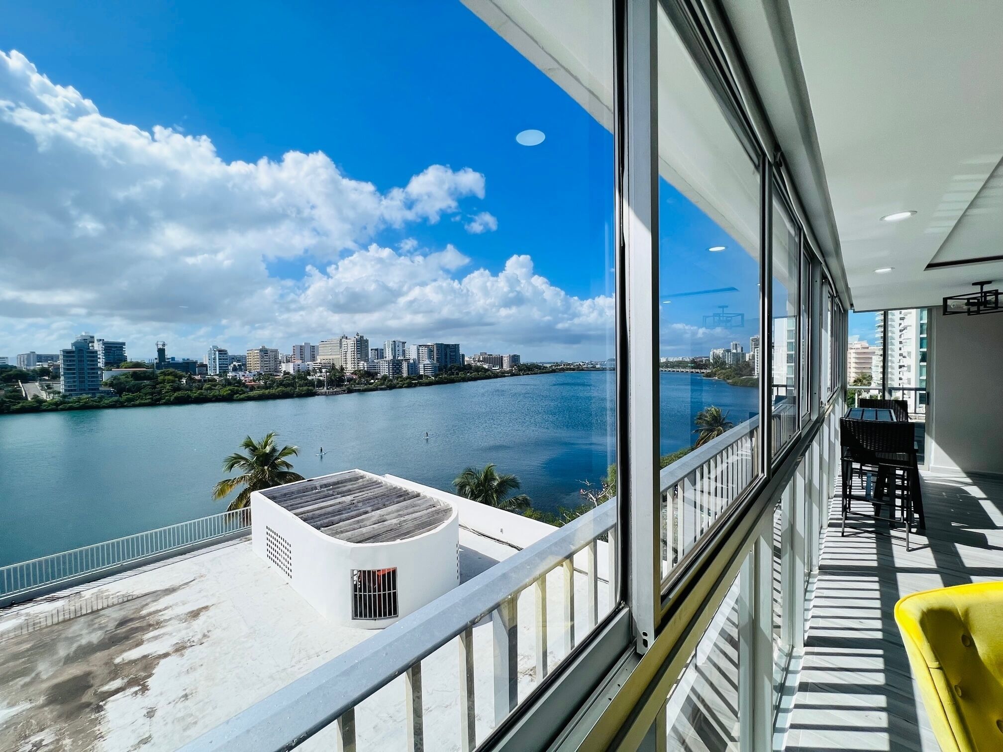 A balcony with a view of a river and city skyline.