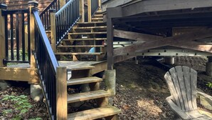 Una scala in legno conduce a un patio con una sedia e un tavolo.