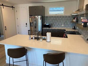 Enjoy cooking in this well-equipped kitchen with a central island and bar stools.