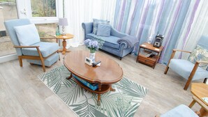 Una sala de estar con una mesa de centro de madera, un sofá azul y un sillón azul.