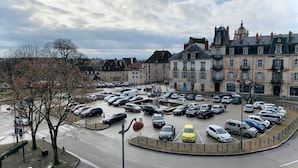 A parking lot with multiple cars and a historic building in the background. - ★Studio Frères Lumière★Centre ville Dole - Wifi Netflix (Dole)