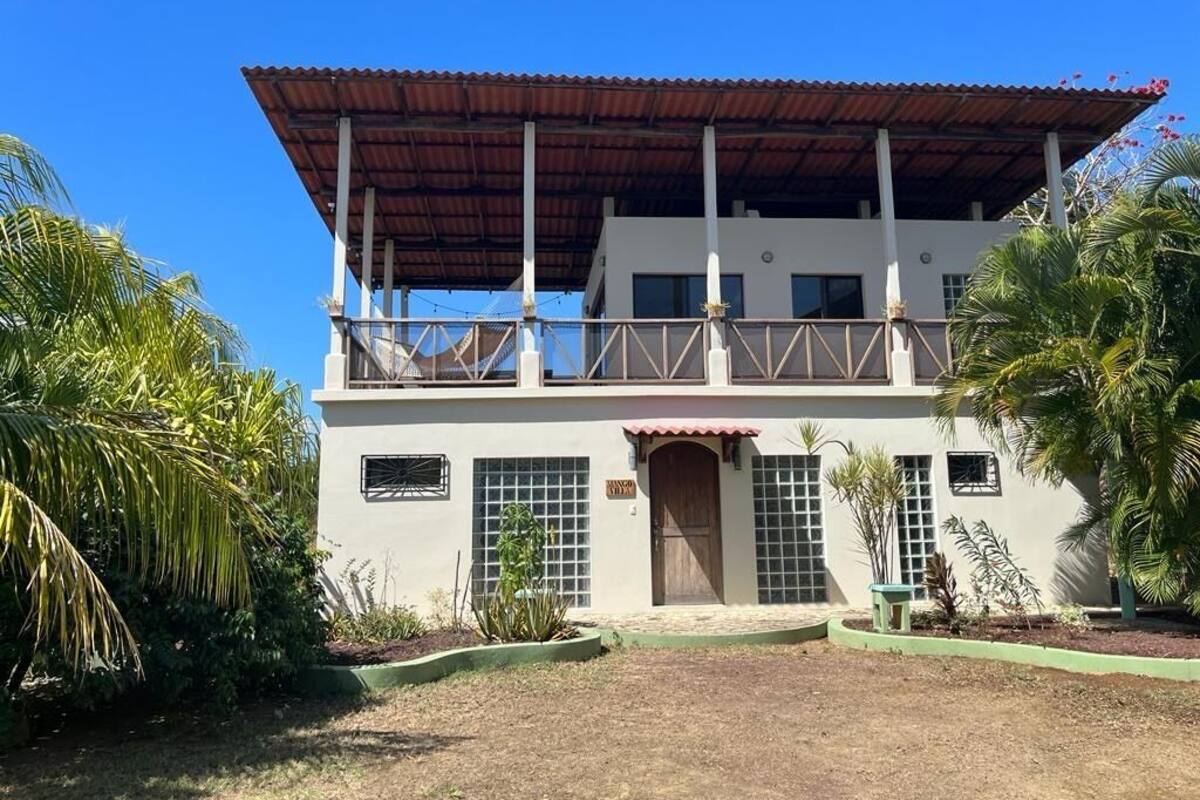 A two-story building with a balcony, a wooden door, and a sign that reads "Casa."