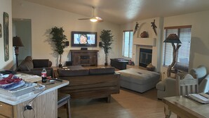 Una sala de estar amplia con chimenea, televisor y comedor.