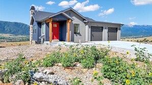 A modern house with a red door, garage, and a driveway. - Experience luxury at BMS14 | Copper Peak Retreat, a 3BR home in scenic Eden, UT. (Eden)
