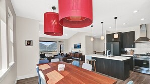 A modern kitchen with a central island, stainless steel appliances, and red pendant lighting. - Experience luxury at BMS14 | Copper Peak Retreat, a 3BR home in scenic Eden, UT. (Eden)