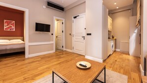 Una sala de estar moderna con una mesa de centro de madera, un sofá y un televisor montado en la pared.