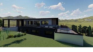 Ein modernes Haus mit flachem Dach, großen Fenstern und einer Dachterrasse.