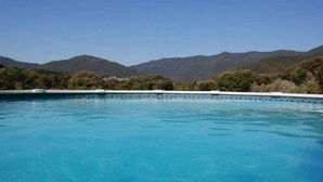 Una piscina blava i nítida amb una vista de muntanyes al fons.