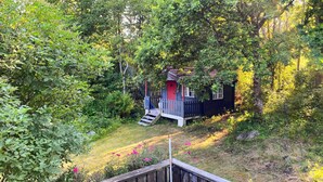 A secluded cabin surrounded by dense forest, with a small wooden deck leading to the entrance. - Beautiful home in Falkenberg with WiFi (Falkenberg)