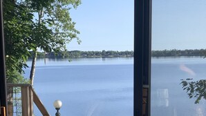 Un chien sur une terrasse en bois, avec vue sur un lac.