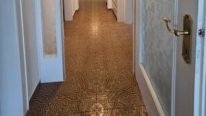 A hallway with patterned carpet, white walls, and a door with a brass handle. - Apart Weinberg 1 - 8 persons vacation apartment (Gemeinde Imst)