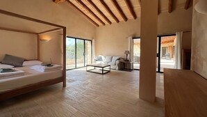 Une chambre spacieuse avec un lit à baldaquin, un canapé et une table.