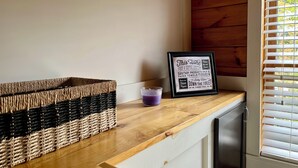 Keittiön työtasolla on rottinkikori, pieni violetti astia ja kehystetty kyltti, jossa on ohjeita jätevesijärjestelmän käytöstä.