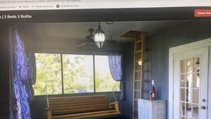 Una habitación con una cama, un banco, una ventana y una puerta.