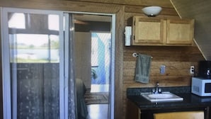 Una cocina con armarios de madera, un lavamanos y un microondas.