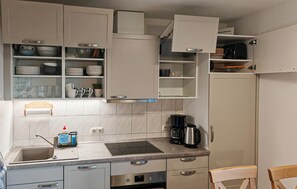 A modern kitchen with white cabinets, a stainless steel sink, and a built-in oven. - Lovely home in Wohlenberg with WiFi (Wohlenberg)