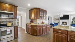 A kitchen with wooden cabinets, a built-in oven, and a granite countertop.