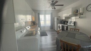Una cocina compacta con comedor, ventilador de techo y un reloj en la pared.