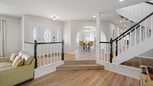 A spacious living area with a staircase, a dining area, and a sofa.