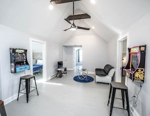 Relax in this stylish living area with a high ceiling, exposed beams, and a comfortable sofa.