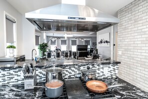 Enjoy cooking in this well-equipped kitchen with a large island, stove, and ample counter space.