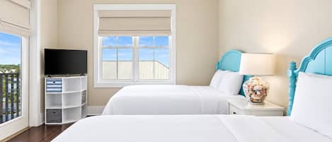 A hotel room with two beds, a TV, and a window with a view.