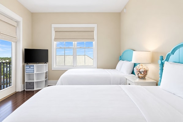 A hotel room with two beds, a TV, and a window with a view.