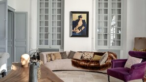 A living room with a curved sofa, a purple armchair, and a framed painting on the wall. - Beautiful home in Léognan with sauna (Léognan)