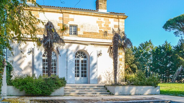 A two-story building with a pool, arched windows, and a staircase leading to the entrance. - Beautiful home in Léognan with sauna (Léognan)