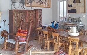 A dining area with wooden chairs and a rocking chair, a tiled floor, and a table with a white pitcher and bowl. - Beautiful home in Léognan with sauna (Léognan)